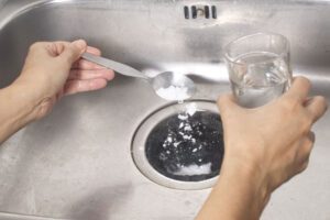 Backpulver als Reinigungsmittel verwenden – unsere Tipps Küchenabfluss wird mit Backpulver gereinigt.