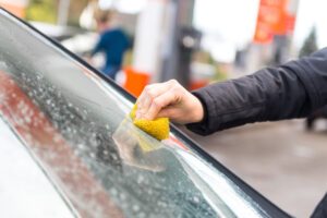 Frau entfernt Insekten von Auto