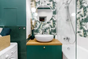 Kleines Badezimmer mit Waschtisch und Badewanne in Grüntönen