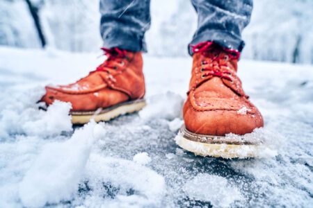 Rote Lederschuhe im Schneematsch bekommen Salzränder.