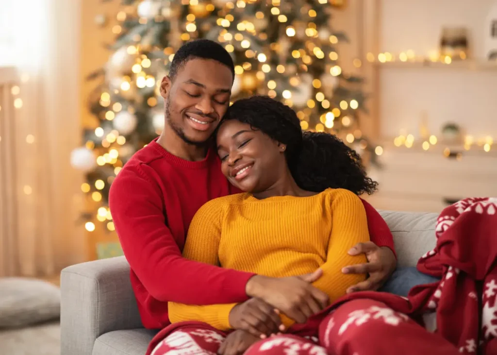 Glückliches Paar zur Weihnachtseit kuschelnd auf einem Sofa Stressfreie Weihnachtszeit – Meine Tipps für ein entspanntes Fest ohne Nervenchaos